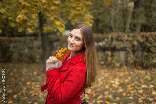 young woman on a walk in the park in autumn in fine weather