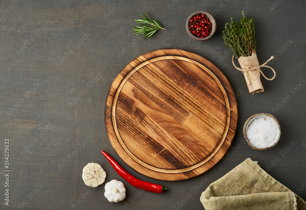 Food seasoning background. Menu, recipe, mock up. Round wooden cutting board on dark backdrop. Food seasoning background. Menu, recipe, mock up. Round wooden cutting board on dark backdrop.