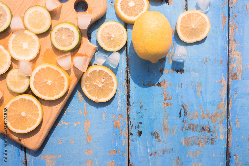 Sliced Lemons and Limes with ice cube. Over blue wood table background with copy space ,spring time concept
