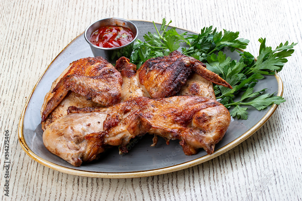 Tapaka chicken in a classic performance with.crispy garlic crust and Georgian sauce Tapaka chicken in a classic performance with.crispy garlic crust and Georgian sauce