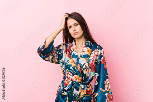 Young caucasian woman wearing a kimono pajama being shocked, she has remembered important meeting. © Asier
