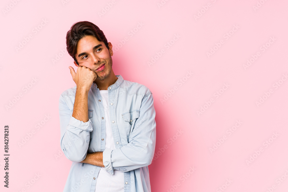 Young caucasian man posing in a pink background isolated who feels sad and pensive, looking at copy space. Young caucasian man posing in a pink background isolated who feels sad and pensive, looking at copy space.