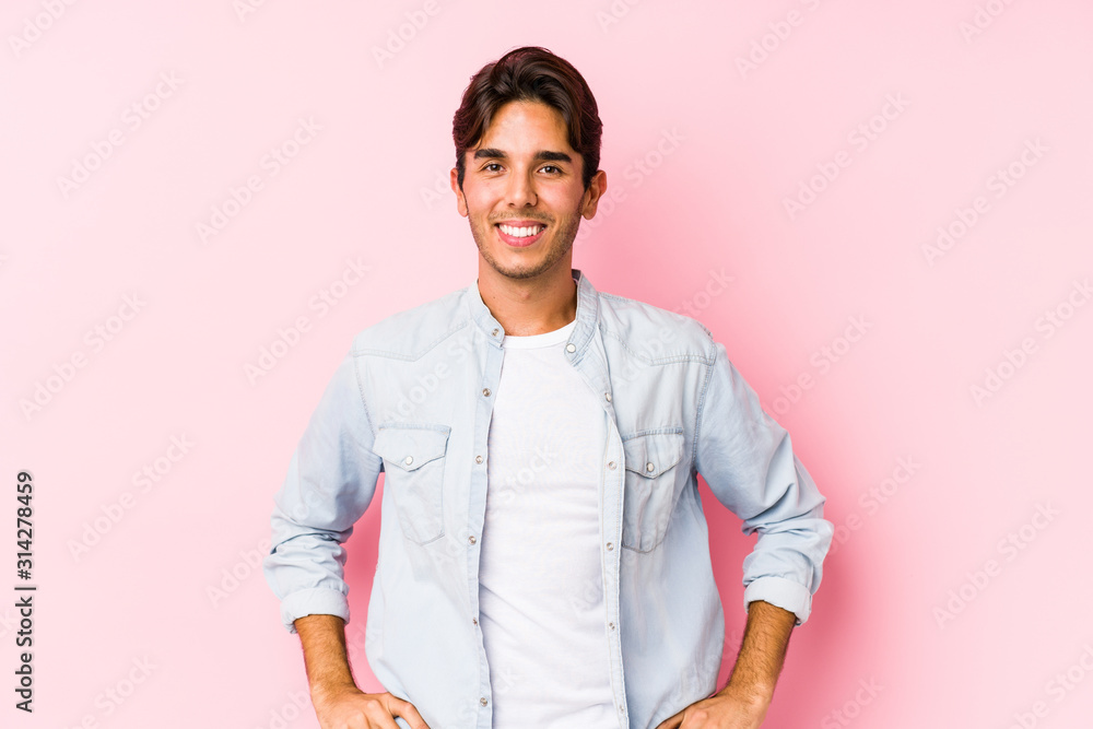 Young caucasian man posing in a pink background isolated confident keeping hands on hips. Young caucasian man posing in a pink background isolated confident keeping hands on hips.