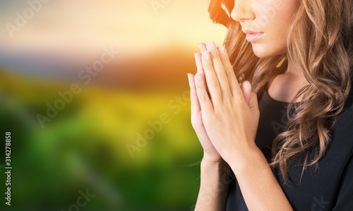 A young beautiful  girl praying on blurs background