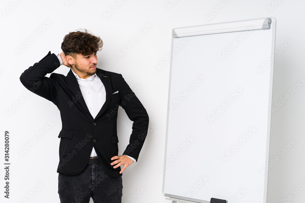 Young business coaching arabian man touching back of head, thinking and making a choice. Young business coaching arabian man touching back of head, thinking and making a choice.