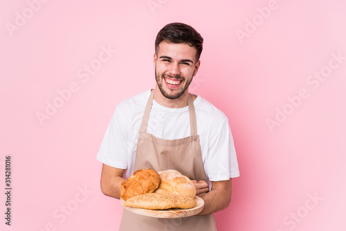 Fototapete Young caucasian baker man isolated laughing and having fun.