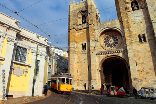 The iconic 28 tram in front of the Cathedral of St. Mary Major, simply called the Sé, into historic Alfama district, Lisbon, Portugal
