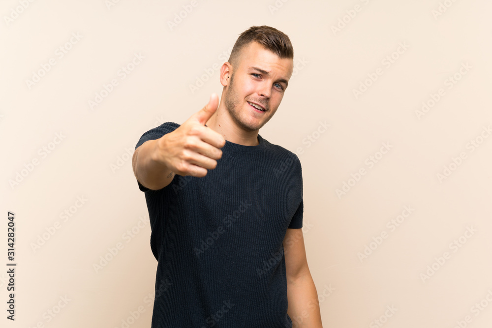 © luismolinero - Young handsome blonde man over isolated background with thumbs up because something good has happened