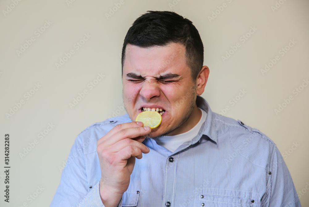 Man eating lemon. Wince from sour taste. Man eating lemon. Wince from sour taste.