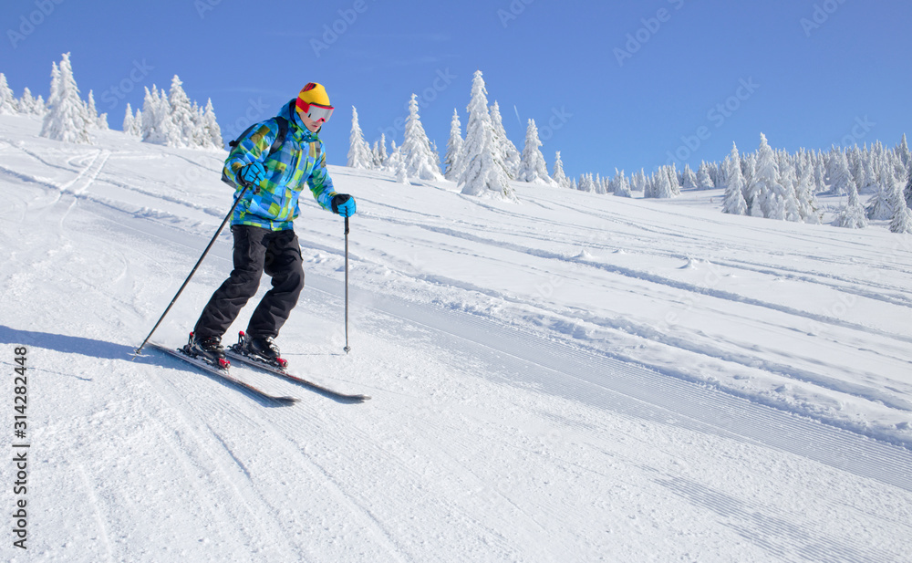 Active Skier skiing downhill on ski piste in mountains Active Skier skiing downhill on ski piste in mountains