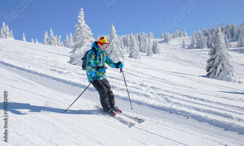 Active Skier skiing downhill on ski piste in mountains	