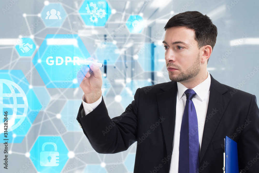 Business, Technology, Internet and network concept. Young businessman working on a virtual screen of the future and sees the inscription: GDPR Business, Technology, Internet and network concept. Young businessman working on a virtual screen of the future and sees the inscription: GDPR