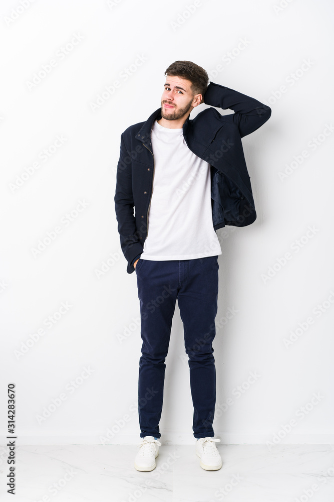 Full body young caucasian man isolated touching back of head, thinking and making a choice. Full body young caucasian man isolated touching back of head, thinking and making a choice.