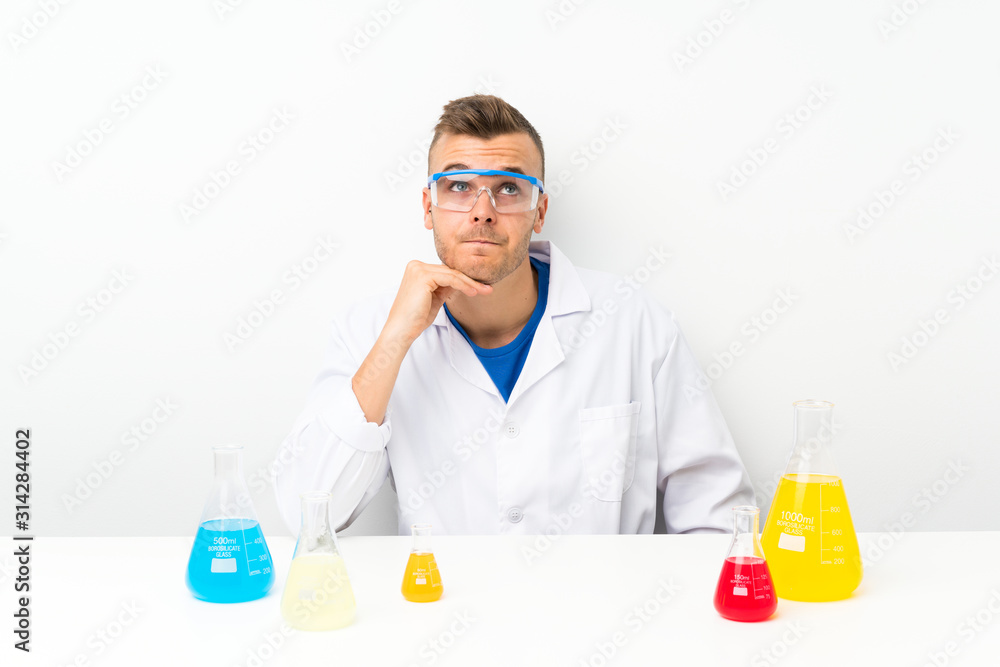 Young scientific with lots of laboratory flask thinking an idea Young scientific with lots of laboratory flask thinking an idea