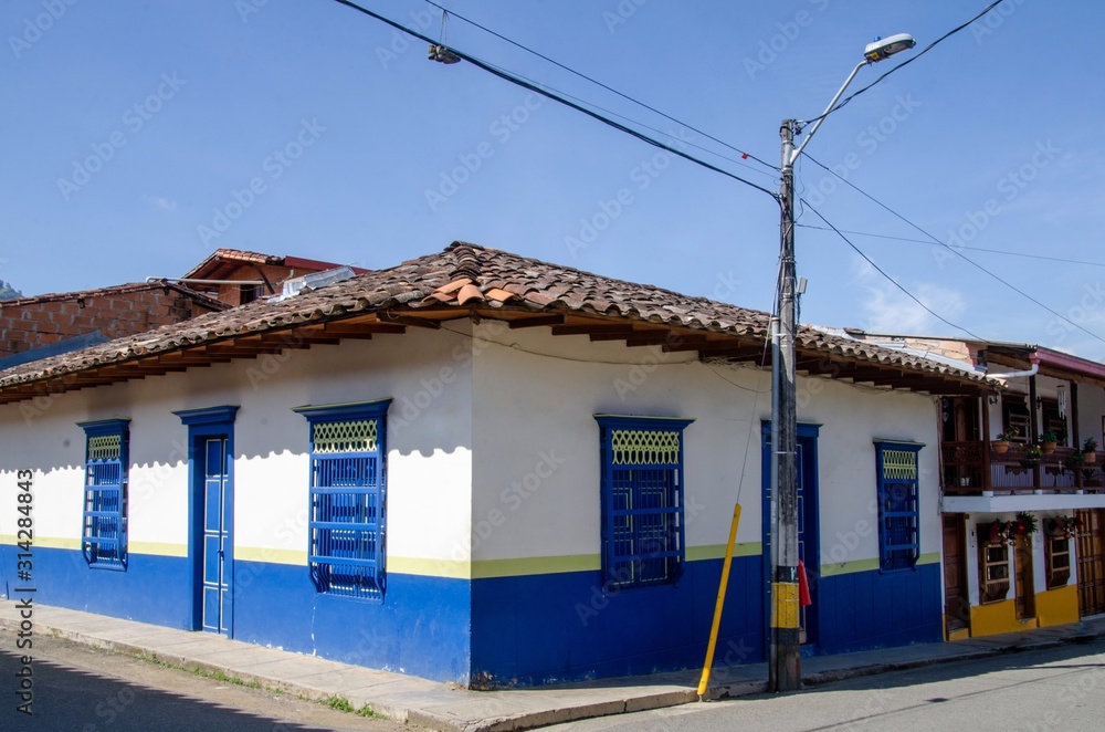Casas en Jardin, Antioquia: puertas y ventanas en madera pintadas de alegres colores sobre fachada blanca,