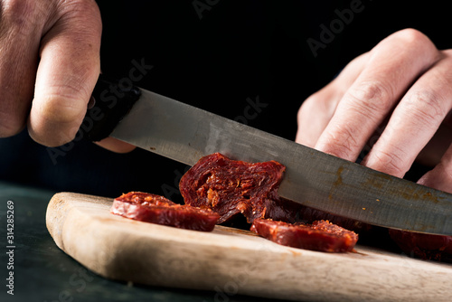 cutting chorizo, spanish cured pork sausage. photo