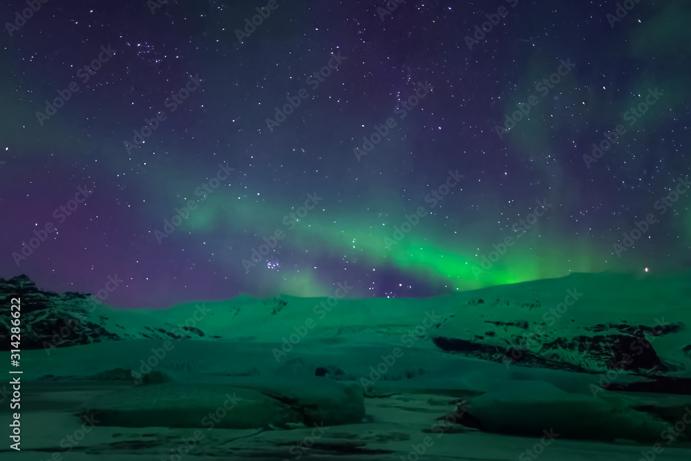 Aurora borealis in night northern sky. Ionization of air particl Aurora borealis in night northern sky. Ionization of air particl