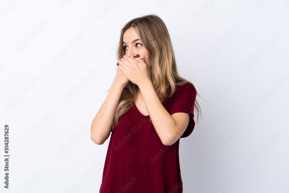 Young woman over isolated white background covering mouth and looking to the side Young woman over isolated white background covering mouth and looking to the side