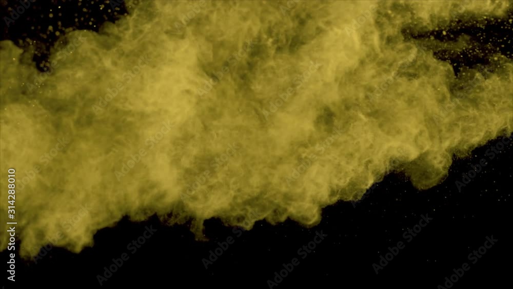 Realistic yellow powder explosion on black background. Slow motion movement with acceleration