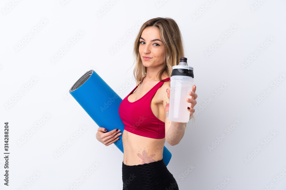 Young sport woman over isolated white background with sports water bottle and with a mat Young sport woman over isolated white background with sports water bottle and with a mat