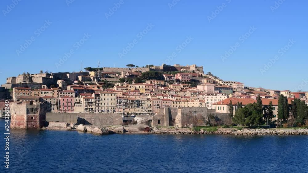 View of Portoferraio, Elba Island, Tuscan Archipelago, Italy. Beautiful sunny day with clear sky. Seen from moving ferry boat or cruise ship View of Portoferraio, Elba Island, Tuscan Archipelago, Italy. Beautiful sunny day with clear sky. Seen from moving ferry boat or cruise ship