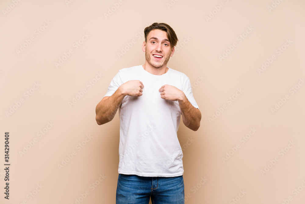 Young caucasian man posing isolated surprised pointing with finger, smiling broadly. Young caucasian man posing isolated surprised pointing with finger, smiling broadly.