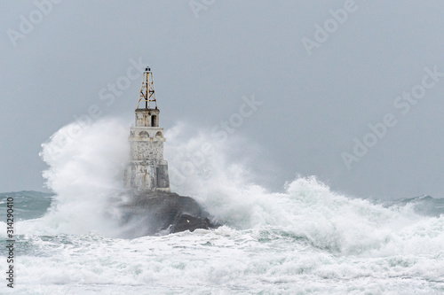 Big waves hit the lighthouse, winter sea storm. 