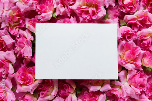 Presentation mockup with white empty blank card on surface with pink flowers roses.