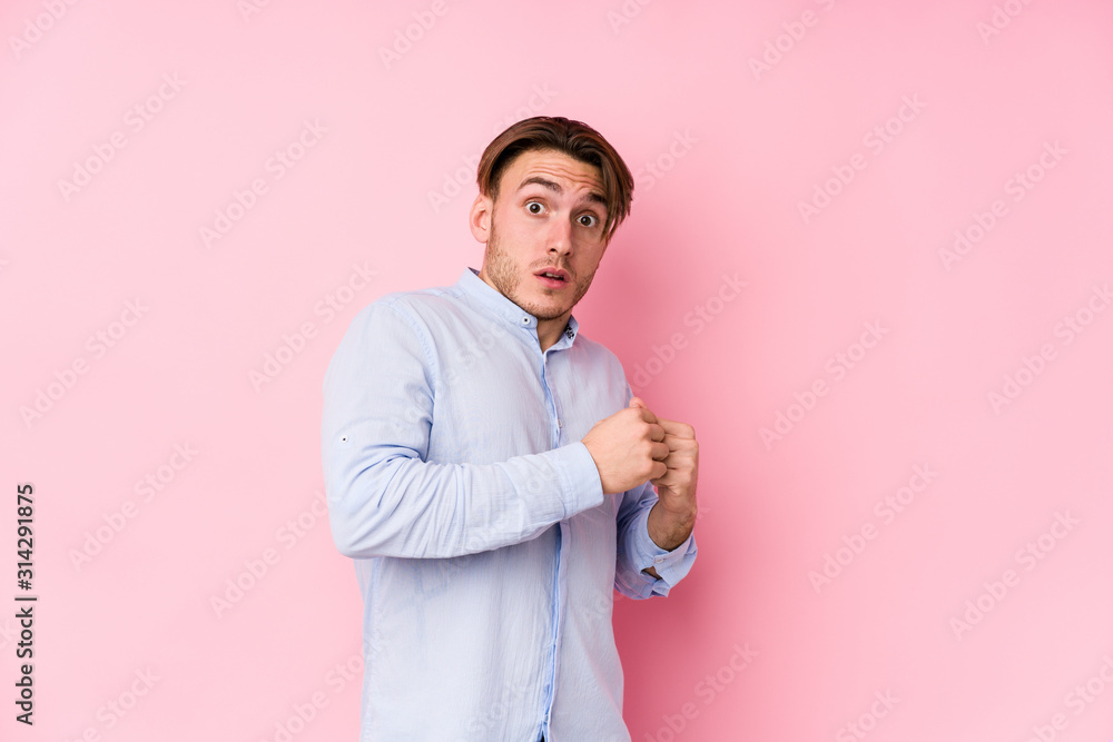 Young caucasian man posing in a pink background isolated scared and afraid. Young caucasian man posing in a pink background isolated scared and afraid.