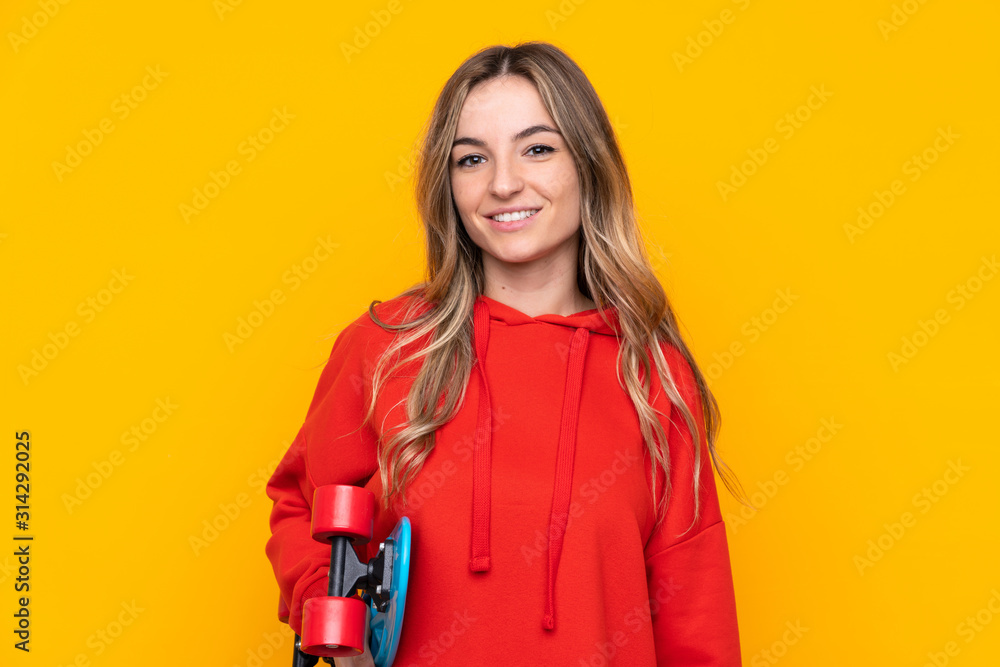 Young woman over isolated yellow background with a skate Young woman over isolated yellow background with a skate
