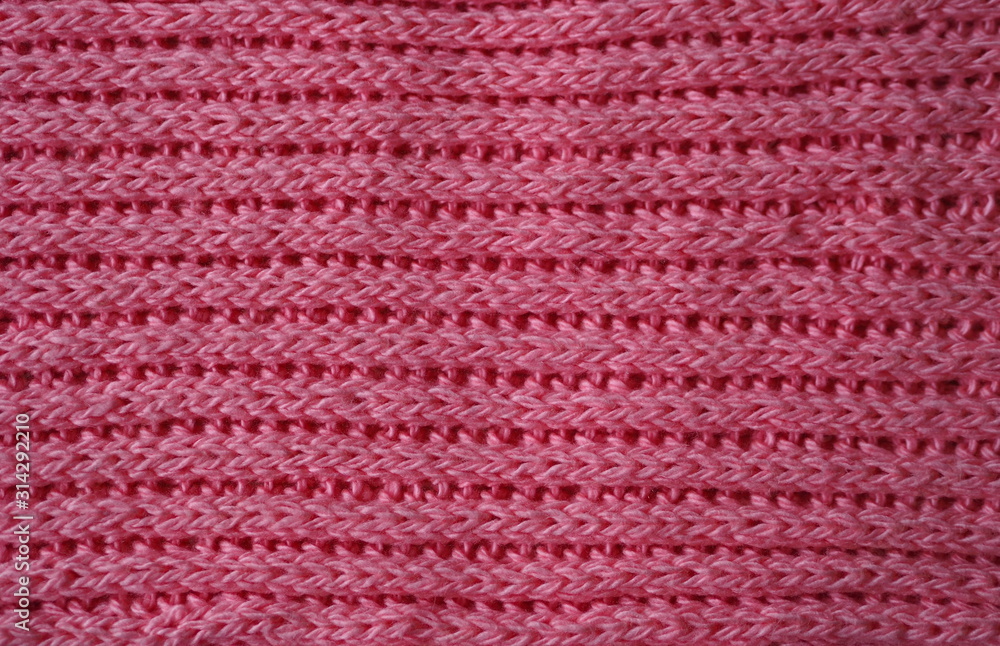 Knitted fabric texture. Pink color. English knitting with front and back loops. Knitting on the knitting needles. Horizontal lines.