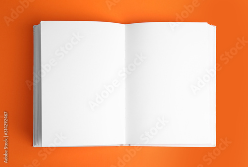 Open book with blank pages on orange background photo