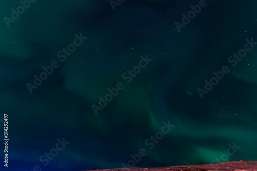 Aurora borealis in night northern sky. Ionization of air particl