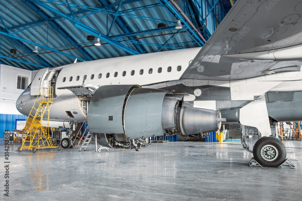 Narrow-body passenger aircraft for maintenance in the hangar, side view of the engine and landing gear.
