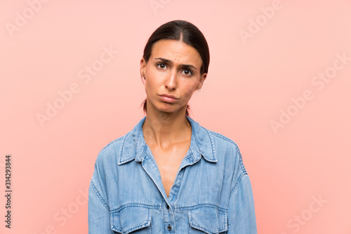 Young woman over isolated pink background sad