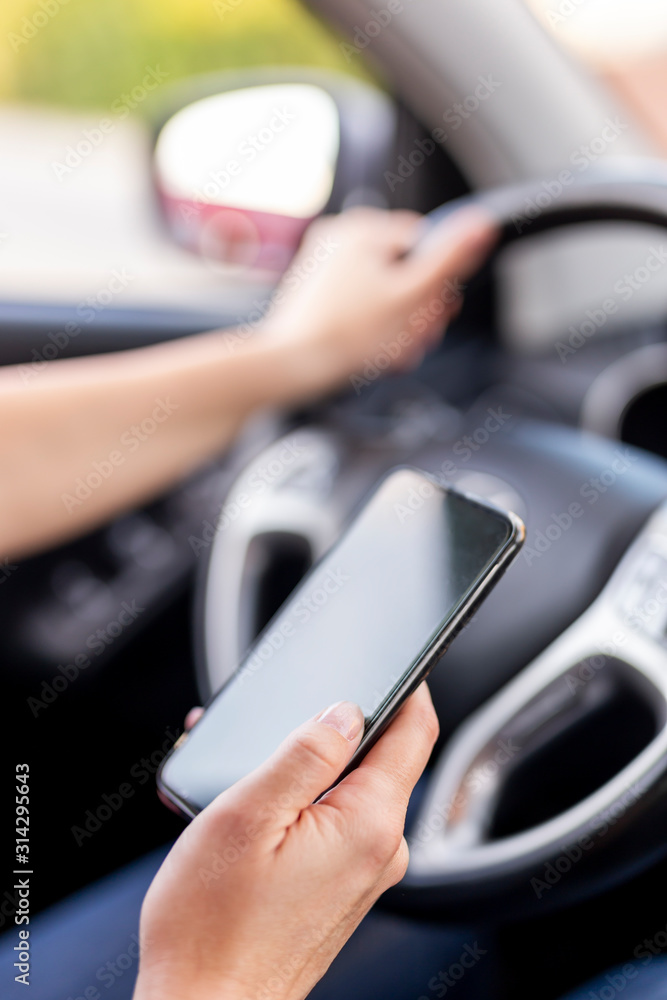 Woman driving a car and typing a text message
