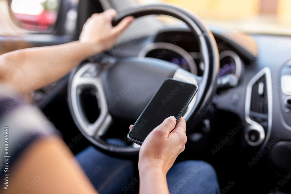 Woman using a phone and driving a car