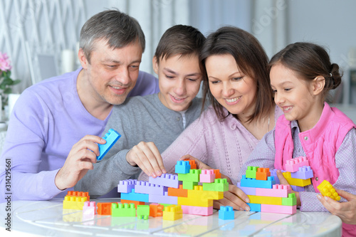 Portrait of happy family collecting colorful blocks