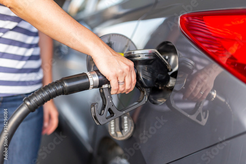 Woman refueling car at petrol station