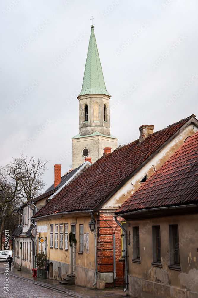 Beautiful view of old countryside brick road street with white church tower in the backgorund. Beautiful view of old countryside brick road street with white church tower in the backgorund.