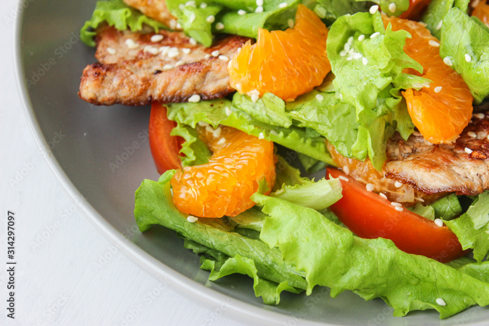 Salad with sweet tangerines and pieces of pork Salad with sweet tangerines and pieces of pork