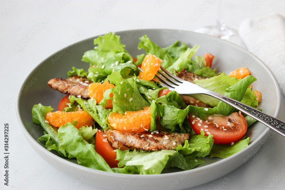 Salad with sweet tangerines and pieces of pork Salad with sweet tangerines and pieces of pork