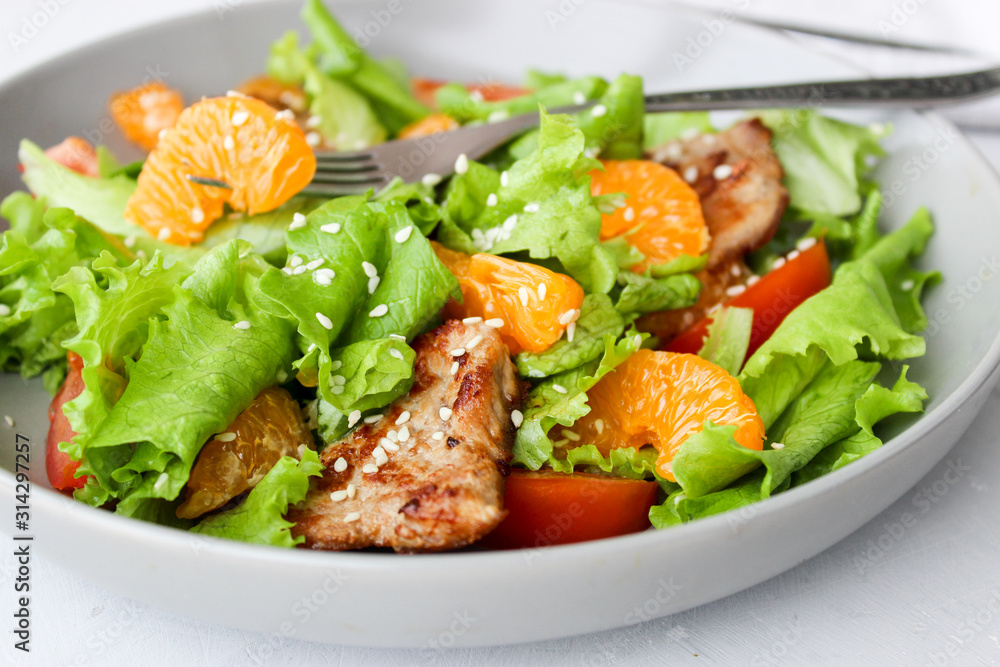 Salad with sweet tangerines and pieces of pork Salad with sweet tangerines and pieces of pork