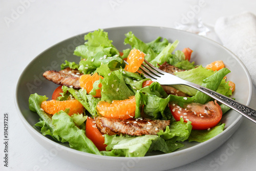 Salad with sweet tangerines and pieces of pork
