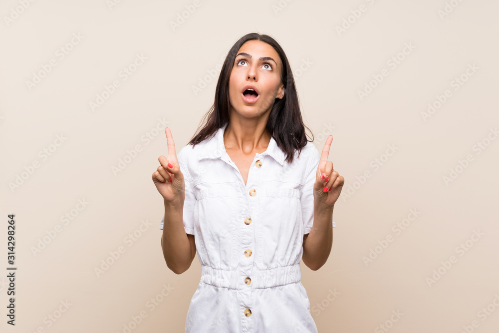 Young woman over isolated background surprised and pointing up Young woman over isolated background surprised and pointing up