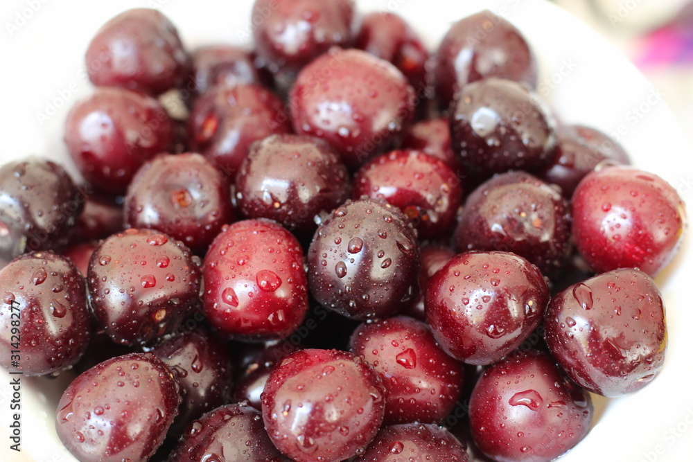 Freshly washed cherry berries lie on a white plate. Freshly washed cherry berries lie on a white plate.