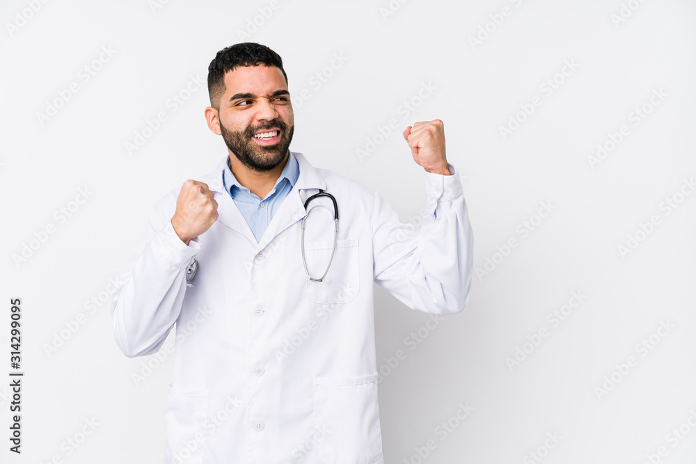 Young arabian doctor man isolated raising fist after a victory, winner concept. Young arabian doctor man isolated raising fist after a victory, winner concept.