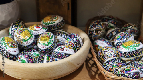 Easter eggs in a wooden plate. Ukrainian traditional hand-painted easter eggs. Souvenirs on the market window, ovals made of wood
