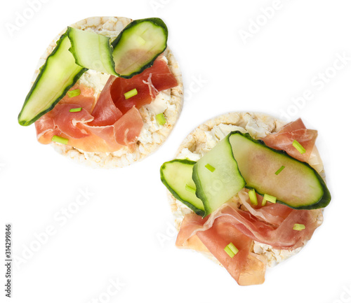 Puffed rice cakes with prosciutto and cucumber isolated on white, top view