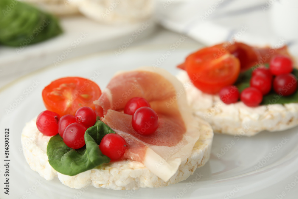 Puffed rice cakes with prosciutto, berries and basil on plate, closeup Puffed rice cakes with prosciutto, berries and basil on plate, closeup